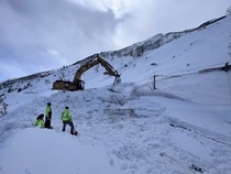 An excavator removes snow and debris from the avalanche closure on U.S. 395 near Mono Lake in March 2023.