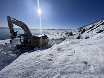 The sun shines on an excavator removing snow and debris from U.S. 395 along Mono Lake in March 2023.