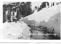 A black and white image of Sonora Pass snow clearing at Fourth of July Cut. Writing on the picture reads "District 9 - Mono County - 13 - A. 6-1-56. E.D.H. M-99. 4th July Cut Snow Pack Opening."
