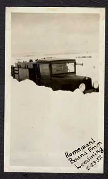 A black and white image of an old truck stopped in the snow in 1932. Writing on the picture reads "Homeward Bound from Lee Vining 2-23-32."