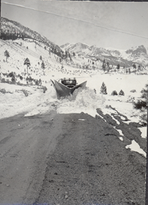 An undated black and white image of an old snowplow removing snow from the highway. This type of plow was used by Caltrans in the 1930s.