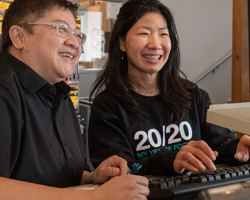Photo thumbnail of a business owner and employee in front of a computer screen, smiling