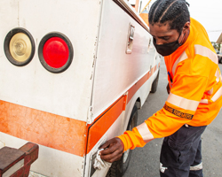 Photo of Caltrans maintenance worker, Shaun Mason cleaning the handles on a Caltrans vehicle with a disinfectant wipe.