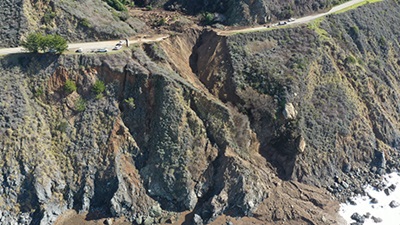Aerial photo from February 1, 2021, showing debris up canyon and washout of California's Highway 1, on the Big Sur Coast at Rat Creek. Debris flow from the Dolan Fire burn scar washed out a 150-foot section of roadway January 28, 2021, causing a full closure.