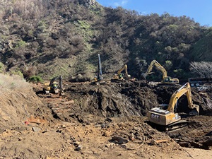 Photo from February 11, 2021, with excavators removing debris from canyon on California's Highway 1, on the Big Sur Coast at Rat Creek. Debris flow from the Dolan Fire burn scar washed out a 150-foot section of roadway January 28, 2021, causing a full closure.