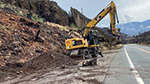A backhoe on State Route 89 near Markleeville, California (about 30 miles south of Lake Tahoe) on the site of an emergency Caltrans project to clear mudslide debris so that the road can be reopened.