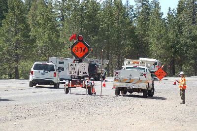 The trailer-mounted Automated Flagger Assistance Device has a remotely controlled mechanical arm that raises and lowers to direct traffic through a work zone.