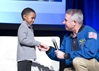 Retired astronaut Dr. Stephen Robinson (right) tells four-year-old Samuel that his wish to see a real spaceship is being granted by Make-A-Wish® Northeastern California and Northern Nevada chapter. In January, Samuel and his family will visit the Kennedy Space Center..