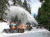 The Caltrans Long Barn Sierra Pass Crew, (left to right and front to back) Erik Young, Tim McGrath, Jim Longeway, and Steve Belit pose with the new PistenBully snow cat, while Serge Kiriluk is operating the blower.