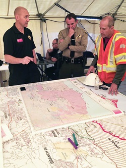 Nov.13, Caltrans District 7 Director John Bulinski (right) discusses the Woolsey and Hill fires with Cal Fire Law Liaison John Davis (left), while a law enforcement officer looks at the map of the area.