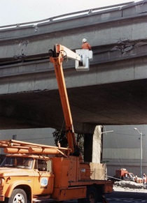 On Oct. 18, 1989, the day after the Loma Prieta earthquake, a Caltrans worker looks between the Cypress site’s decks for vehicles. Rescue and then recovery operations continued there for almost three weeks.