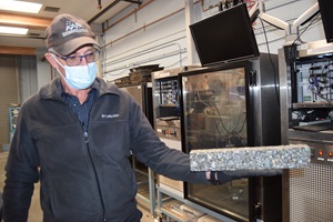 District 3: David Jones, associate director, displaying a brick of asphalt and crushed rock being test in the center’s lab