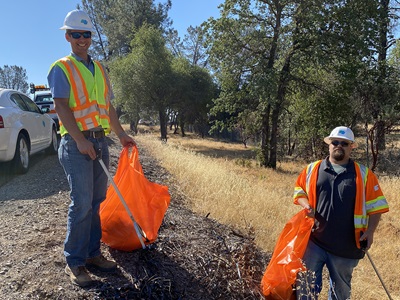 Deputy District Director of Maintenance and Operations Michael Webb and District Water Manager Bill McMahan picking up litter near Shasta View Drive and SR 44 eastbound off ramp in early July