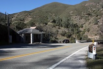 The small visitors center, for the Merced River Recreation area, is tucked between SR-140 and the river, and is surrounded by hills.