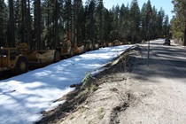 A stockpile of snowplow equipment stands lined up and ready to roll as Highway 20 climbs ever higher into the Sierra Nevada.