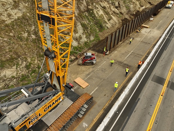 A 500 foot tall crane to assist with installing wire netting on slope and a “soldier pile” retaining wall under construction along Pacific Coast Highway within the Palisades Fire burn zone in Malibu in District 7.   