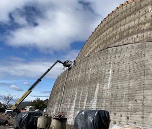 A retaining wall under construction on state route 20 near Blue Lakes. Construction equipment is at work on the wall. 