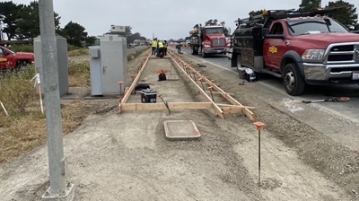 Construction crews pour concrete into the forms of a new sidewalk along Route 1 in Fort Bragg. 