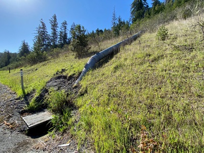 A metal downdrain lays across a hill adjacent to U.S. 101 in Humboldt County.