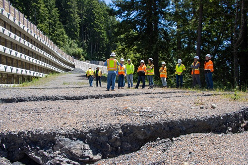 Orange-clad Caltrans staff marvel at the engineering feat duing a tour of Last Chance Grade on U.S. 101 in Del Norte County.