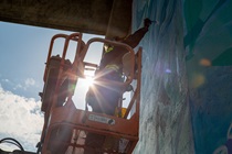 Artist Laci Dane works on a massive mural at Samoa Bridges.