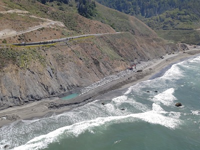 Large rocks are positioned at the base of the bluff to stabilize and prevent erosion.