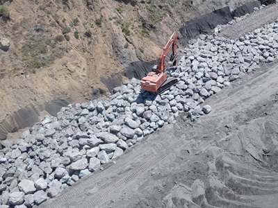 Large rocks are positioned at the base of the bluff to stabilize and prevent erosion.