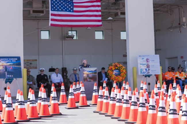 Image showing top to bottom the Unitated States flag, a group of people and orange traffic cones.
