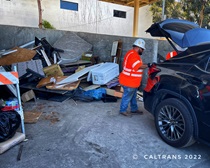 Caltrans employee helping unload trash from a black car. For more information, call (619) 688-6670 or email CT.Public.Information.D11@dot.ca.gov