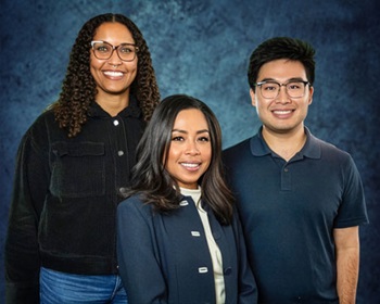 Three persons in front of a blue background.