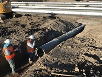 December 2019 – Two construction workers inspect a drainage pipe. For more information call (619) 688-6670 or email CT.Public.Information.D11@dot.ca.gov