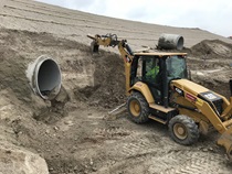 January 2020 – A backhoe digs around a drainage pipe. For more information call (619) 688-6670 or email CT.Public.Information.D11@dot.ca.gov