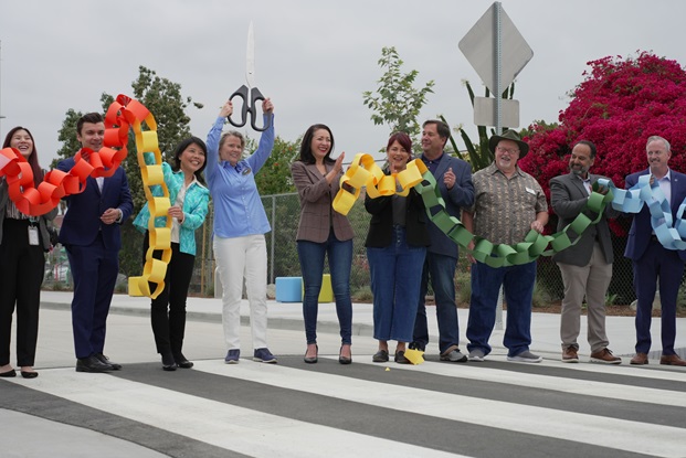 Caltrans District 12 Director Lan Zhou (3rd from left) cuts ribbon alongside Council Members Natalie Meeks and Natalie Rubalcava (4th and 5th from left).