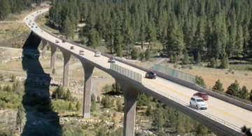 Traffic camera view of the Truckee Bypass bridge on State Route 267 in Truckee. It is a clear day with blue skies and traffic is traveling normally over the bridge.