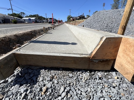 Freshly poured concrete curb along State Route 49 in Auburn as part of a sidewalk gap closure project.