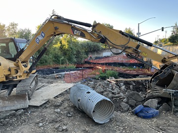 Construction equipment along State Route 49 in Auburn at Rock Creek, where crews are working on drainage ahead of a new pedestrian bridge.