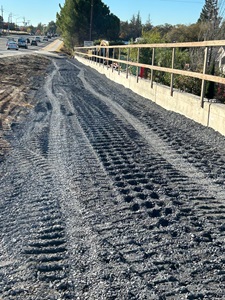 Crews place new backfill along newly constructed wall as part of a sidewalk gap closure project along State Route 49 in Auburn.