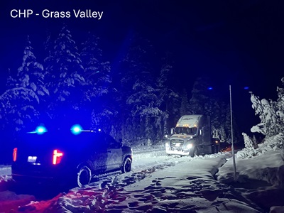 Semi-trucks stuck on snow covered road in rural area of Sierra County, image courtesy CHP Grass Valley.