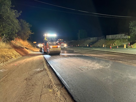 Crews rolling fresh asphalt along State Route 49 in Placer County as part of a safety barrier and roundabout project.