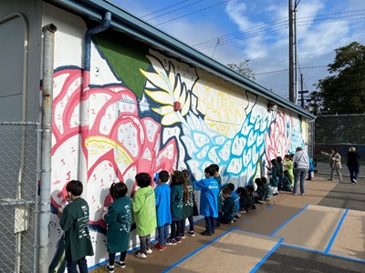 image of dozens of kids painting the wall 