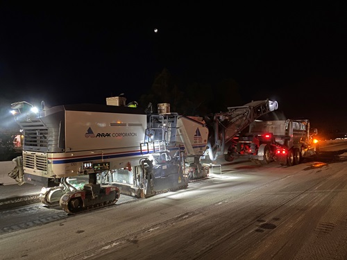 Construction crews grinding the freeway surface to prepare for paving
