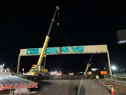 Construction crews working in the freeway lanes to remove an overhead sign in March 2021