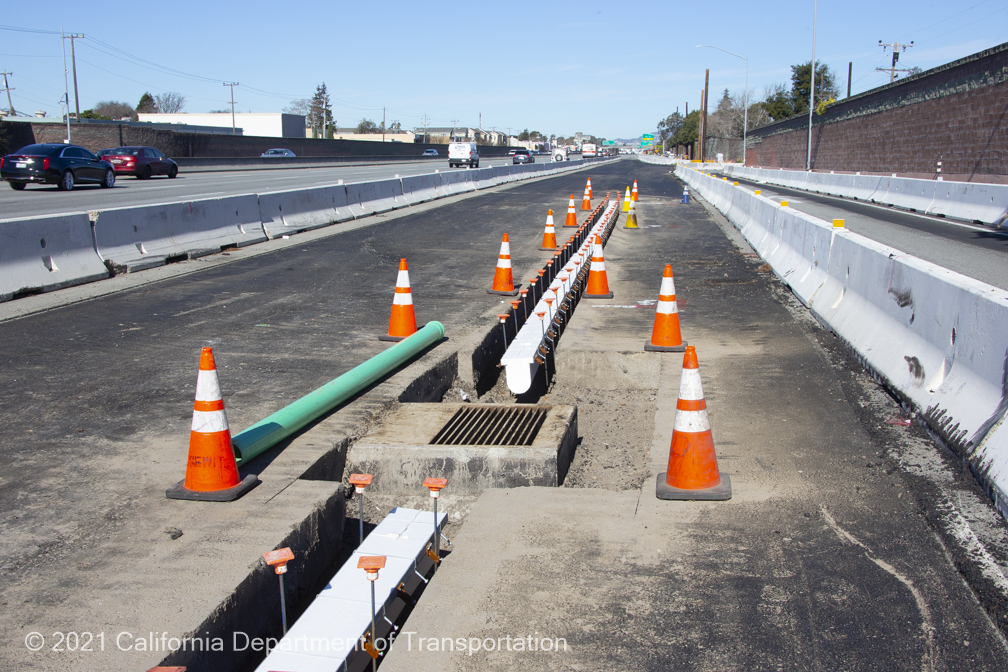 A stormwater drainage system being reconfigured in the freeway shoulder