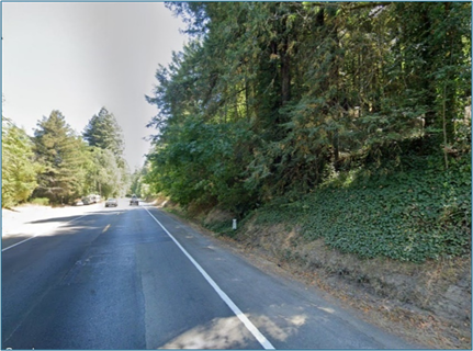 Photograph of State Route 116 near Monte Rio in Sonoma County. The roadway is lined by a tree-covered hillside.
