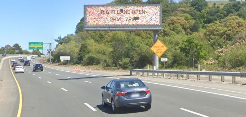 Cars traveling on Eastbound Interstate 580 Richmond-San Rafael Bridge passing a Caltrans Changeable Message Sign (CMS). 