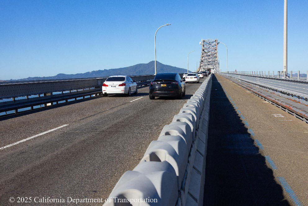Two lanes of traffic travel next to the bike lane on the top deck of the Richmond-San Rafael Bridge between Marin and Contra Costa County.