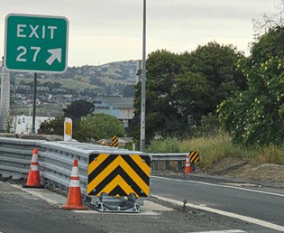 A sign indicates Exit 27 to the right with a barrier separating the exit lane from eastbound Interstate 80 in Contra Costa County.