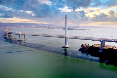 Photograph of the eastern span of the San Francisco-Oakland Bay Bridge. The city of Oakland can be seen in the background.