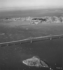 Aerial view of the Richmond-San Rafael Bridge with Red Rock Island in the foreground and Point San Pablo in the background.