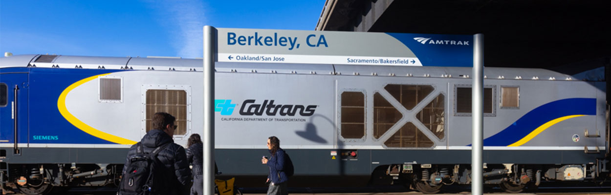 Banner image of the Berkeley Amtrak Station passengers walking in front of a train.
